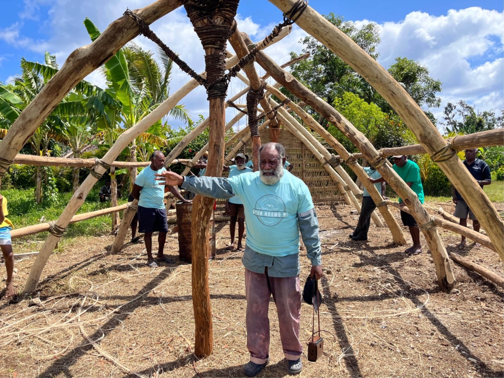 An Erromangan chief inside the frame of a traditional Erromangan building